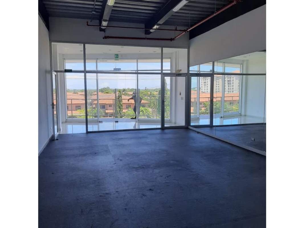 Bright commercial office unit with large windows mirrored wall exposed ceiling in Versalles Business Center Panama