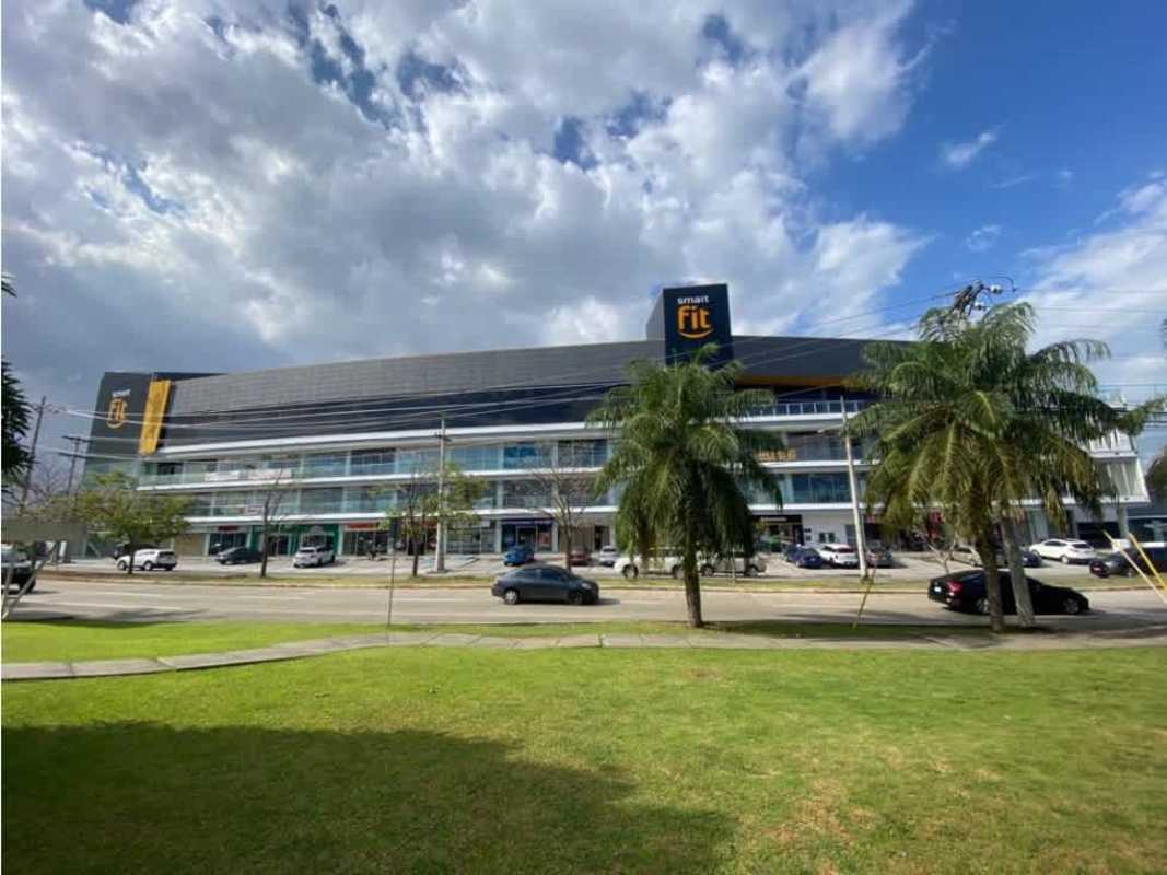 Modern commercial facade with signage and palm trees Costa Sur Panama City