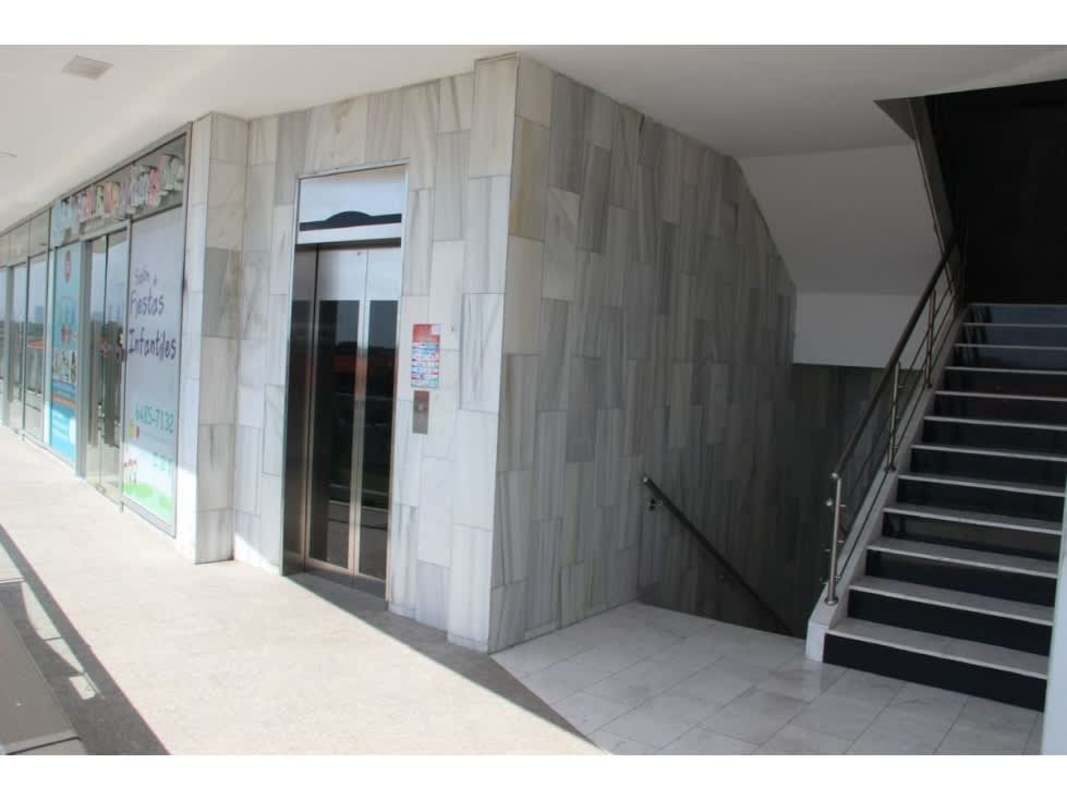 Interior hallway with elevator, glass storefront windows at Versalles commercial plaza Panama
