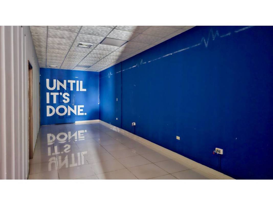 Vacant office space with blue accent wall motivational text and tiled floor in Display Plaza Via Brasil Panama