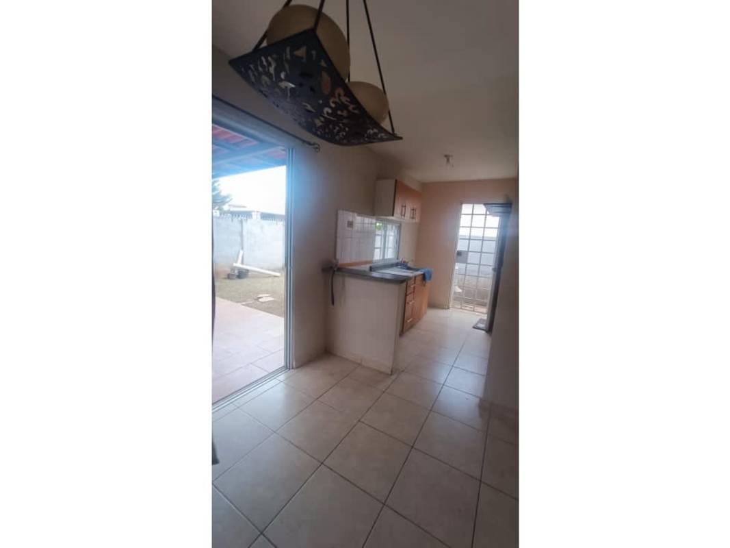 Simple kitchen with tile floors, wooden cabinets and sliding glass door in Arboledas Costa Verde Panama