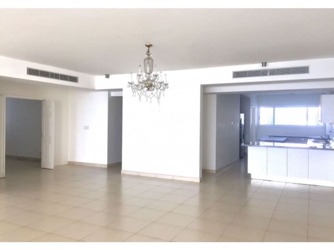 Spacious tiled living space with chandelier open to modern kitchen in Waters on the Bay Panama