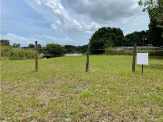Fenced grassy plot on lakefront with wood post fencing Lagomar San Carlos Panama