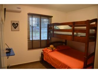 Bedroom with wooden dresser, TV, tiled floor PH Maja country home Penonomé