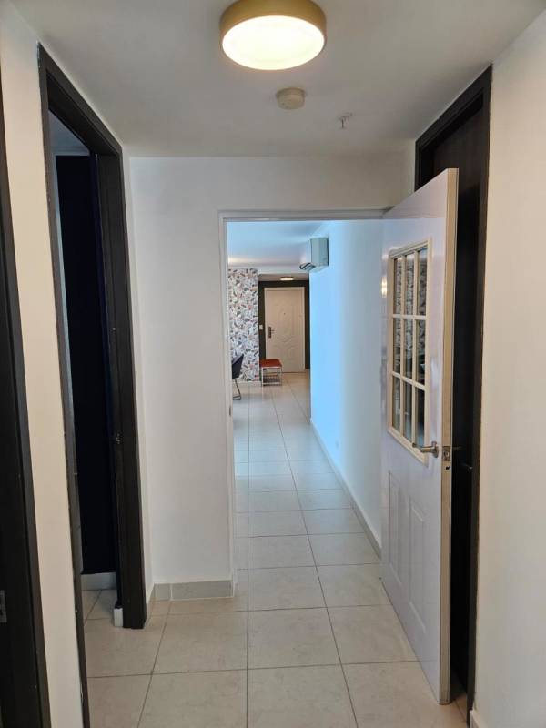 Modern apartment entryway with leaf pattern wallpaper, wall mirror and bench PH Midtown El Cangrejo