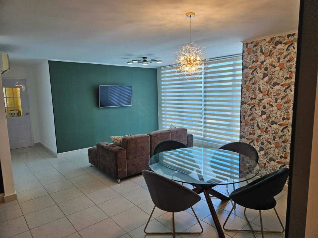 Modern bedroom with accent wallpaper, tufted headboard, window blinds in PH Midtown Panama City