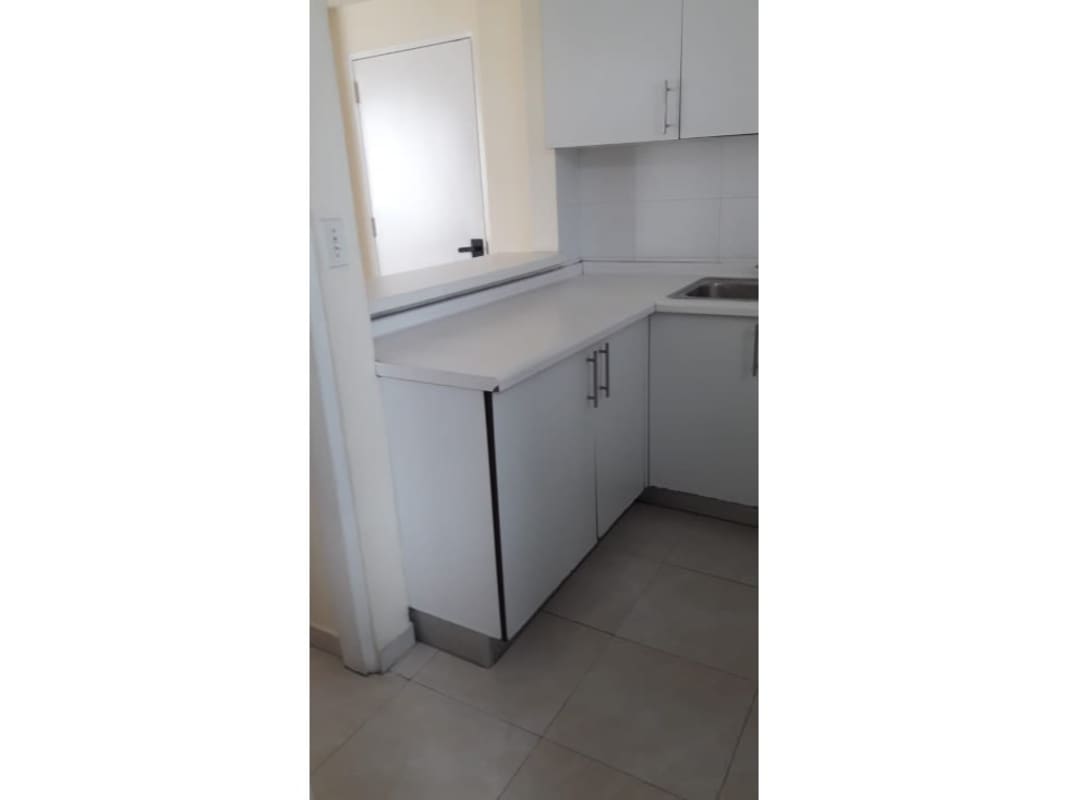 Compact kitchen with stainless refrigerator, gas stove, white cabinets in PH Edison Park Betania