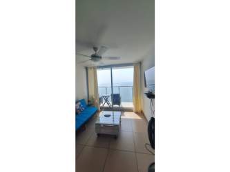 Open living room with blue sofa, ceiling fan, sliding glass doors leading to beach balcony at PH El Palmar in San Carlos