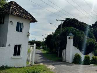 Secure gated entrance with guard booth surrounded by lush greenery in Sol y Mar Playa Blanca