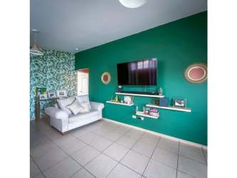 Modern living area with green accent wall, mounted TV, ceramic tile flooring in Arraiján Brisas del Golf