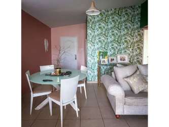 Living room featuring accent wallpaper, floating shelves, ceramic floor, and mounted TV in Brisas del Golf