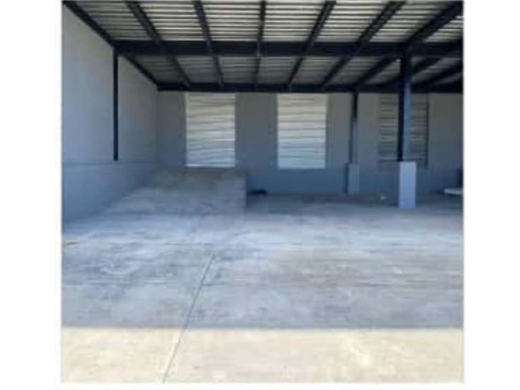 Warehouse space with loading ramp, concrete floors, and mezzanine office at Parque Industrial de Las Americas