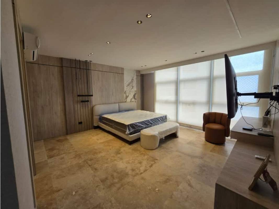 Bedroom with wood panel accent, blinds, large window at PH Q Tower Panama
