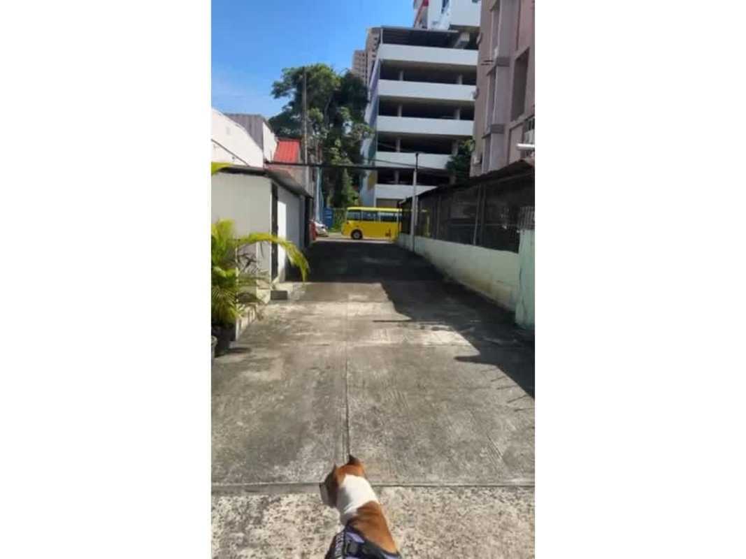 Full view of commercial lot at Via España and Via Porras intersection with retail buildings and parking