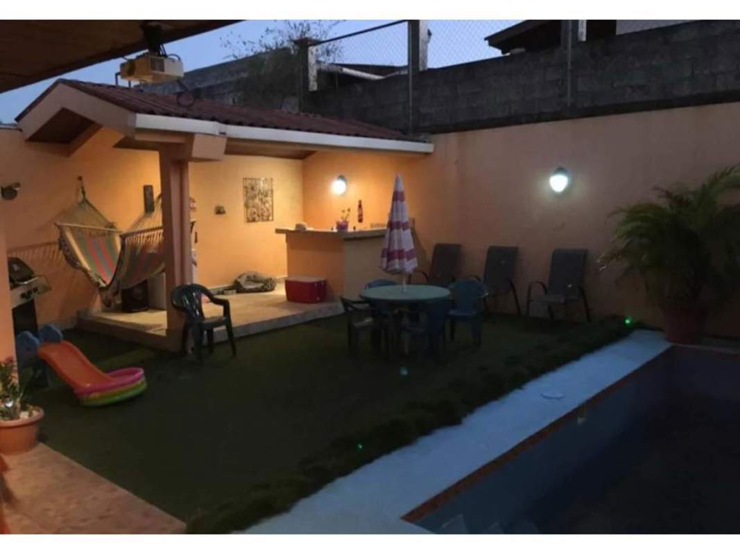 Covered backyard patio with hammock, pool, bar counter, grass, play area in Brisas del Golf