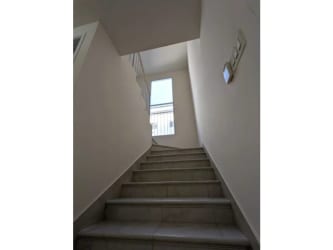 Bright interior stairway with white walls and tile floors inside Playamar beach house Panama