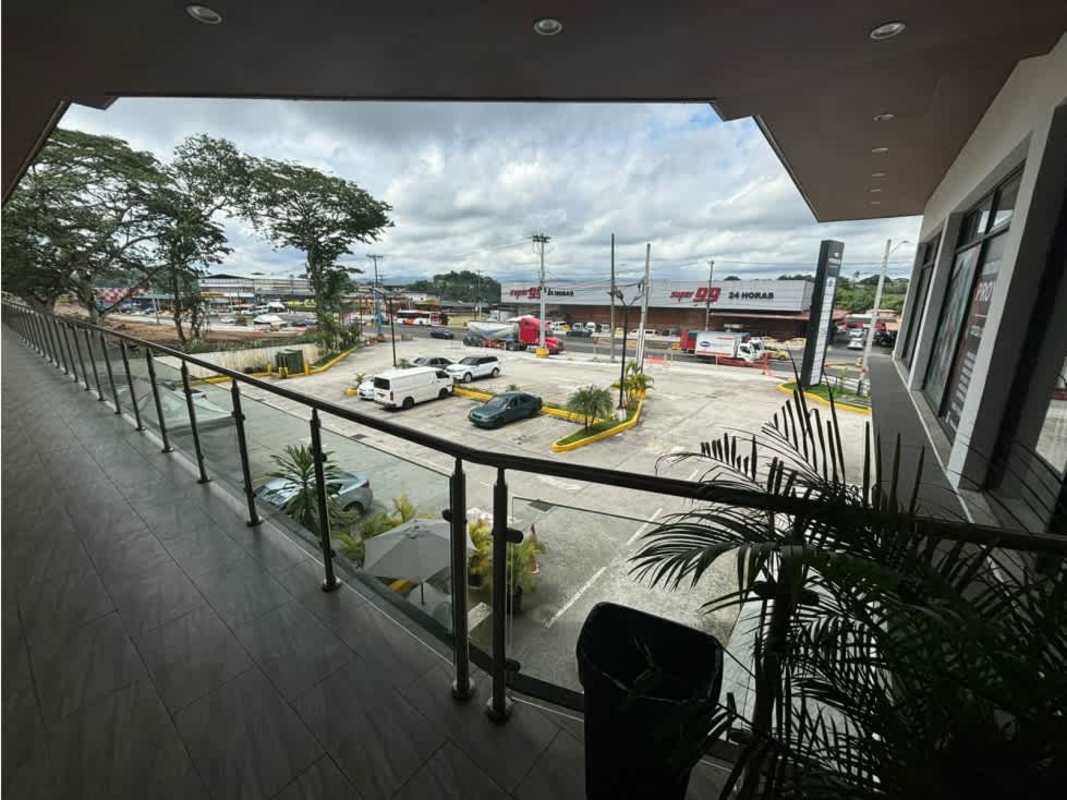 Commercial spaces with glass balcony railings and tiled walkways facing parking lot at Cumbres Plaza La Cabima