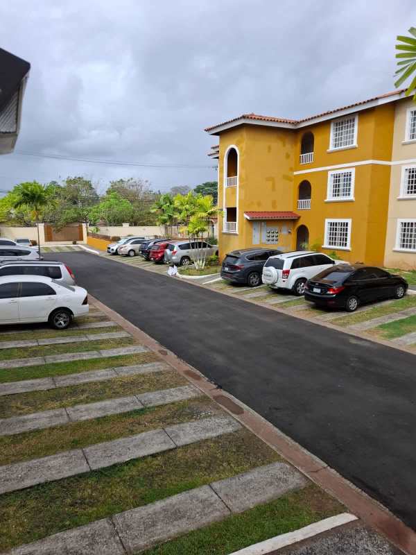 Mediterranean-inspired multi-story apartment complex with parking and palm trees in Panama City