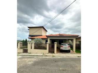 Exterior of two-story gated house with tiled roof and driveway in Penonomé