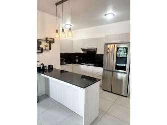 Kitchen with black countertop, white cabinets and appliances Llano Hermoso home