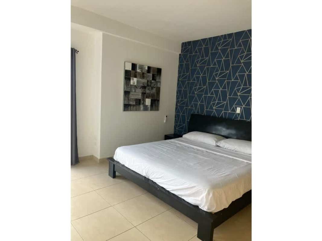 Furnished secondary bedroom with accent wall and large windows PH White Panama