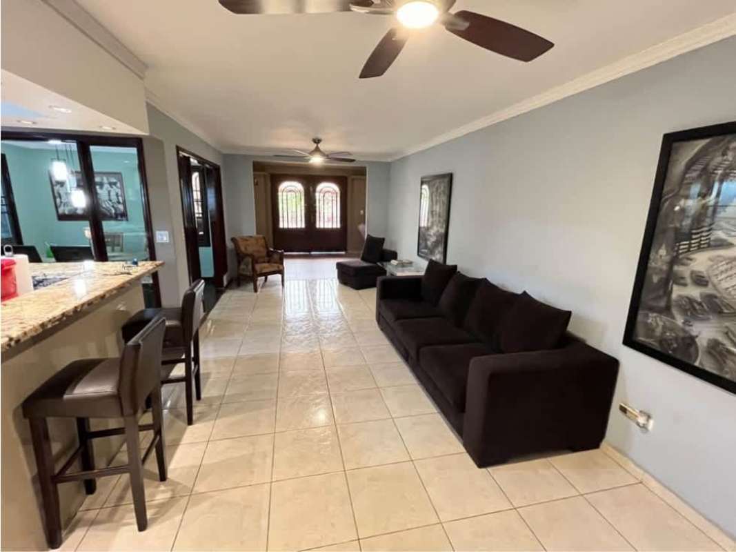 Facade with covered carport, porch at Paseo Miramar house La Chorrera Panama