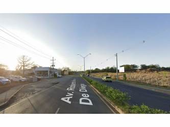 Urban paved road with lighting poles adjacent to open developable lot Chitré Panama