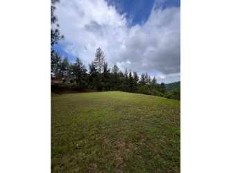 Hillside grassy land with mountain views surrounded by trees Cerro Azul Panama
