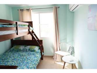 Tropical resort style swimming pool with loungers and palapa huts at PH Paraiso Village Coronado