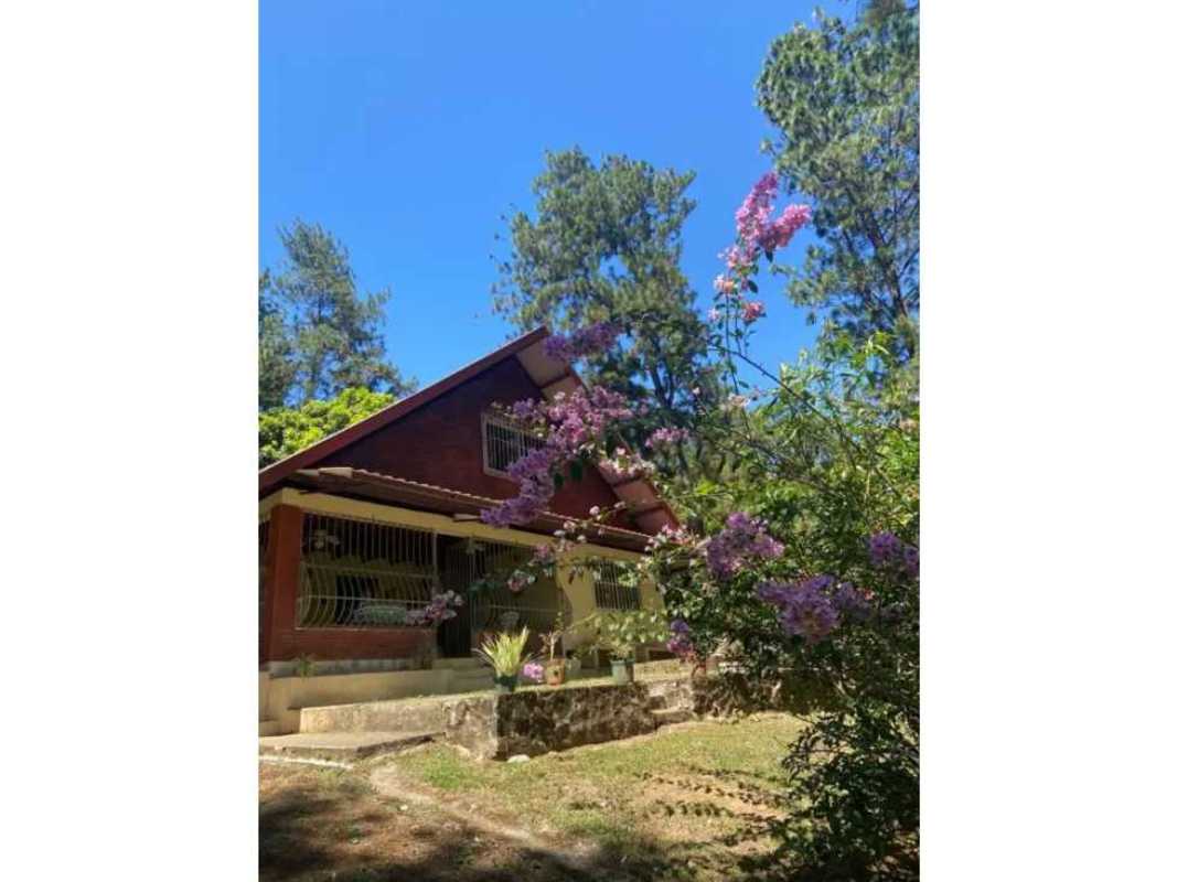 Wood-paneled rustic kitchen and dining area with loft space in mountain cottage Cerro Azul Panama