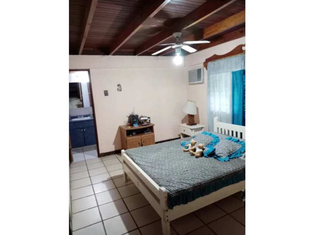 Bedroom with exposed beams and ceiling fan in rustic mountain house Cerro Azul Panama