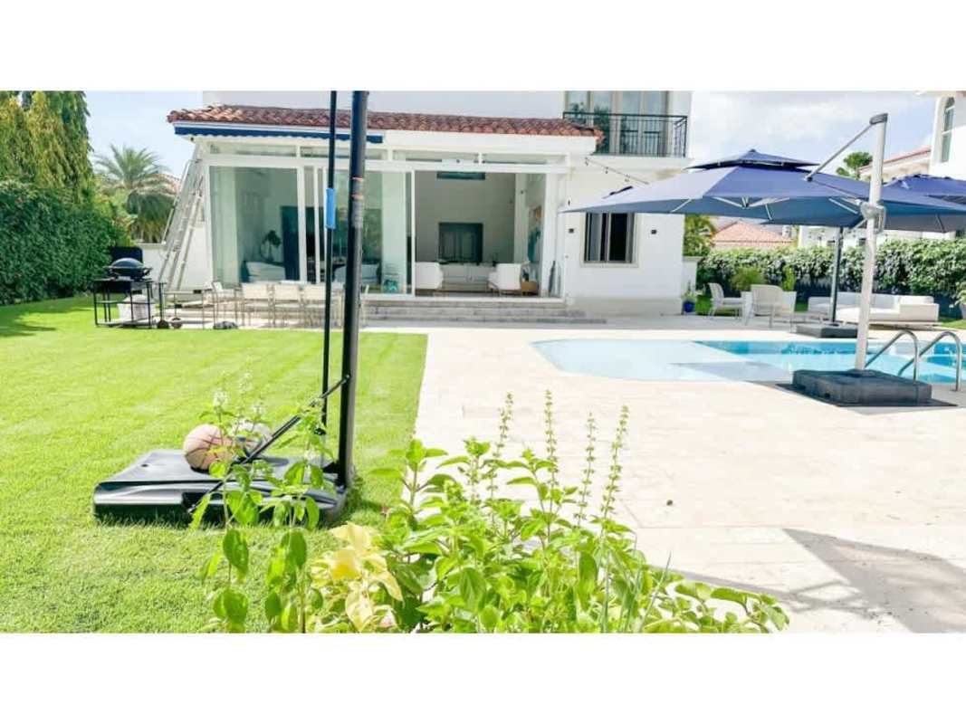 Mediterranean style backyard with pool, umbrellas, and lawns at luxury home Panama