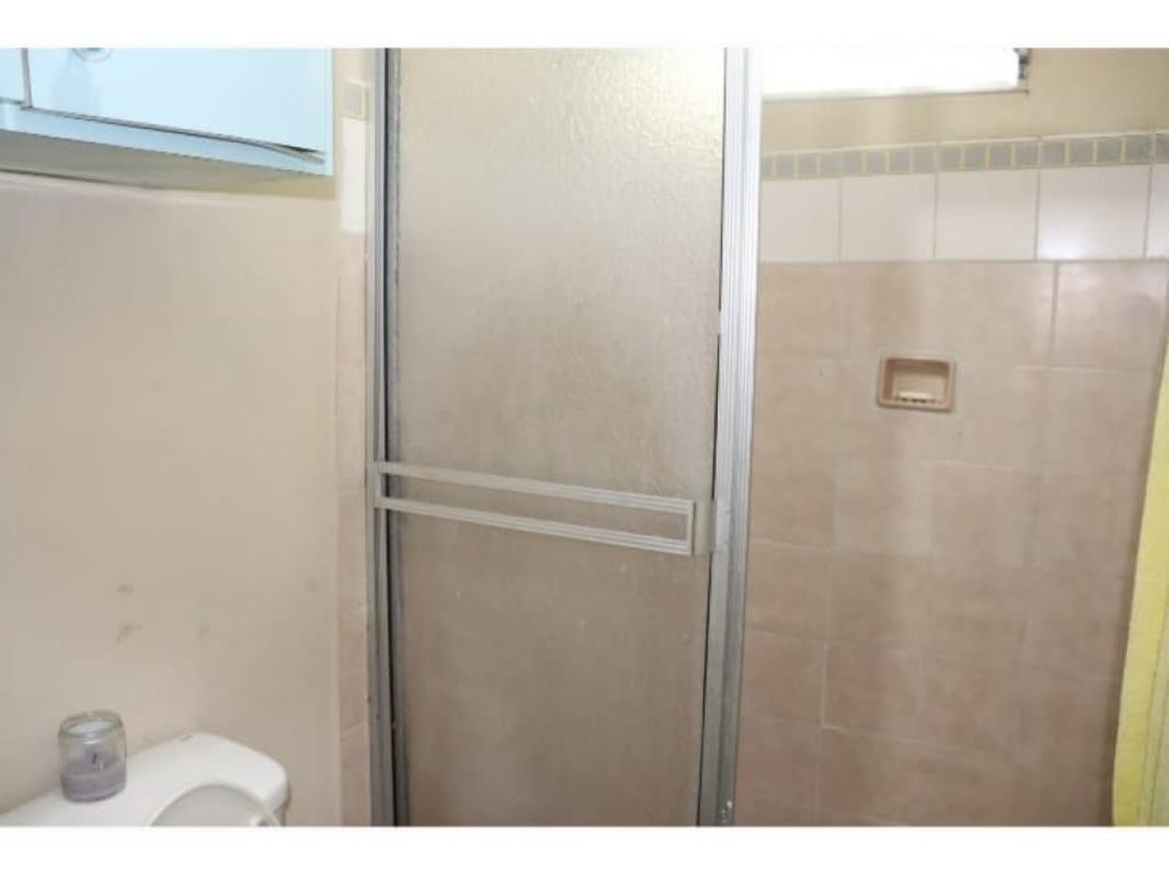 Bathroom with glass door shower and tile finish in Villa Lucre Panama house for sale