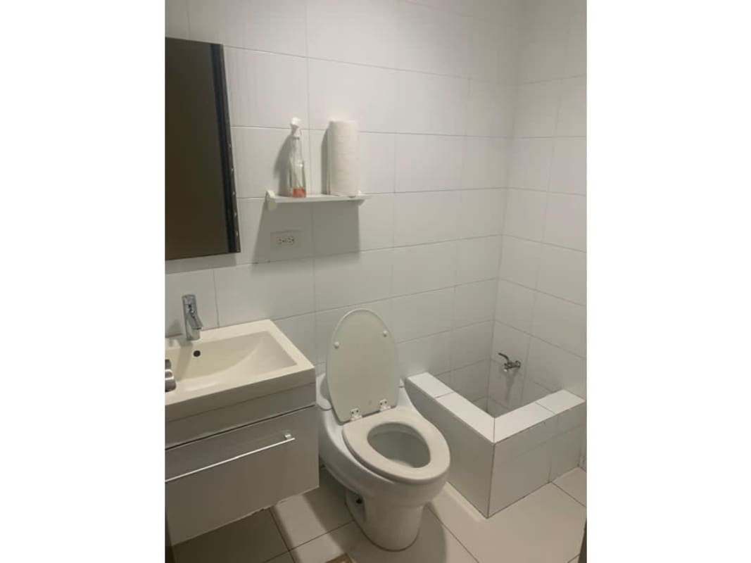 Commercial office bathroom with white ceramic tiles, vanity sink, and mirror in PH Top Tower