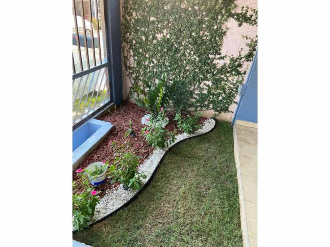 Small private garden with grass, plants and decorative fence at Las Americas house Panama