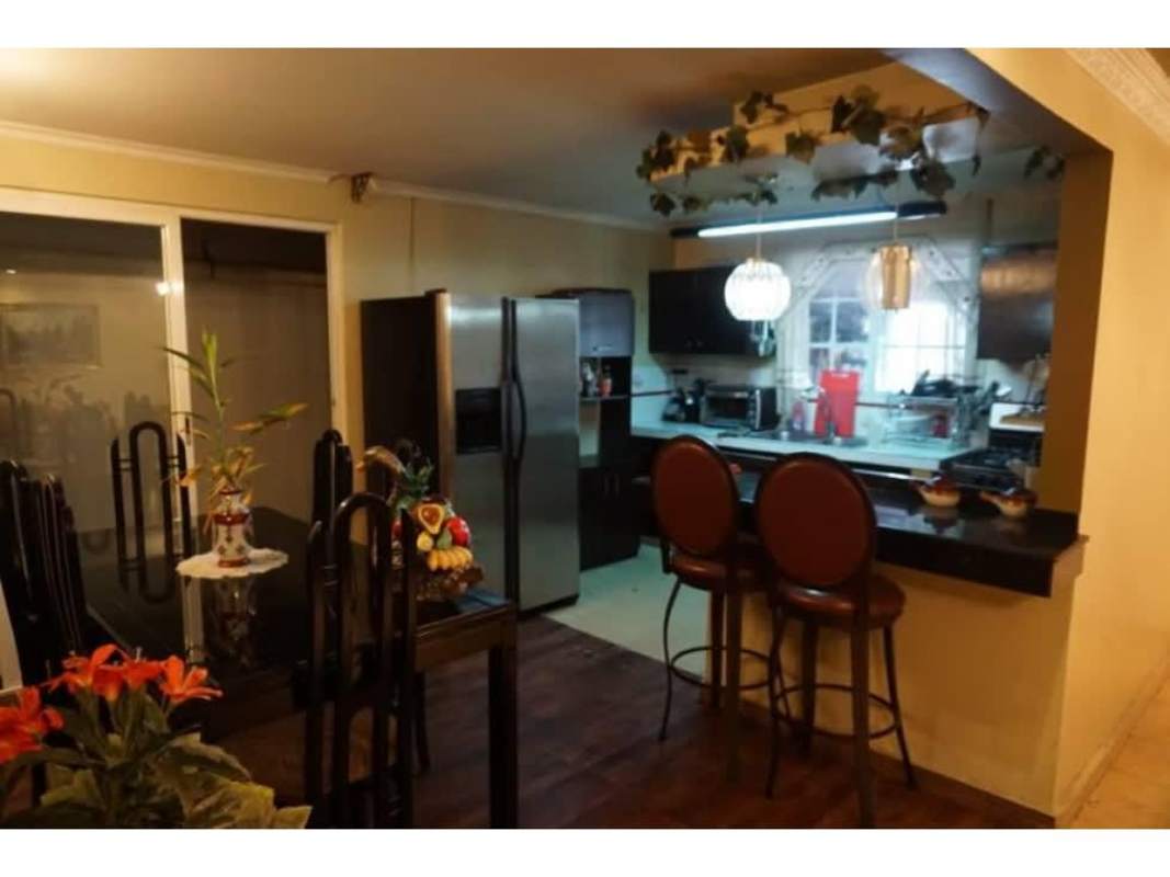 Traditional kitchen with breakfast bar, fridge and pendant lights at remodeled house Las Mañanitas Panama