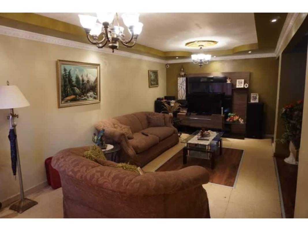 Living room with chandelier, sofas, entertainment center at remodeled house Panama City