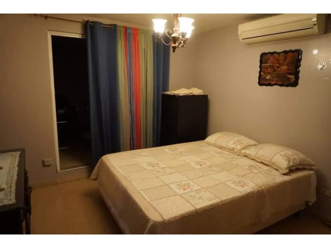 Bedroom with patchwork bedspread, curtain, and AC at house in Residencial Las Americas Panama