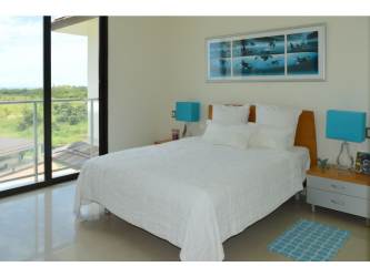 Open living dining area with glass sliding doors and ocean views in Casamar PH Perlamar