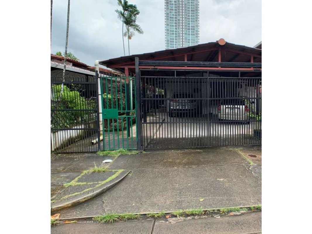 Front gate and carport parking of house with greenery fence and driveway Villa de las Fuentes Panama