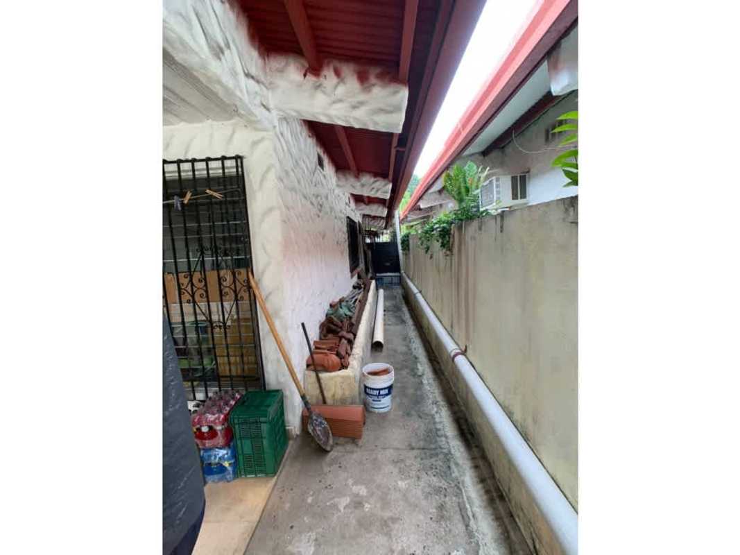 Side walkway with polycarbonate roof and utility pipes residential house Panama