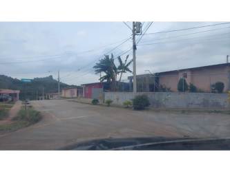 Gravel internal roadway across green development land with trees in Hurtado, La Chorrera Panama