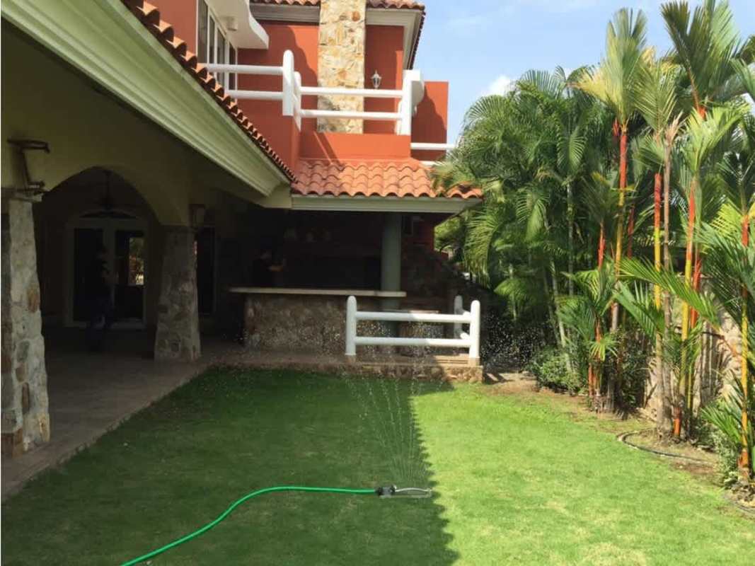 Grand entrance foyer with curved staircase, stone accent wall, double doors luxury home San Francisco Panama