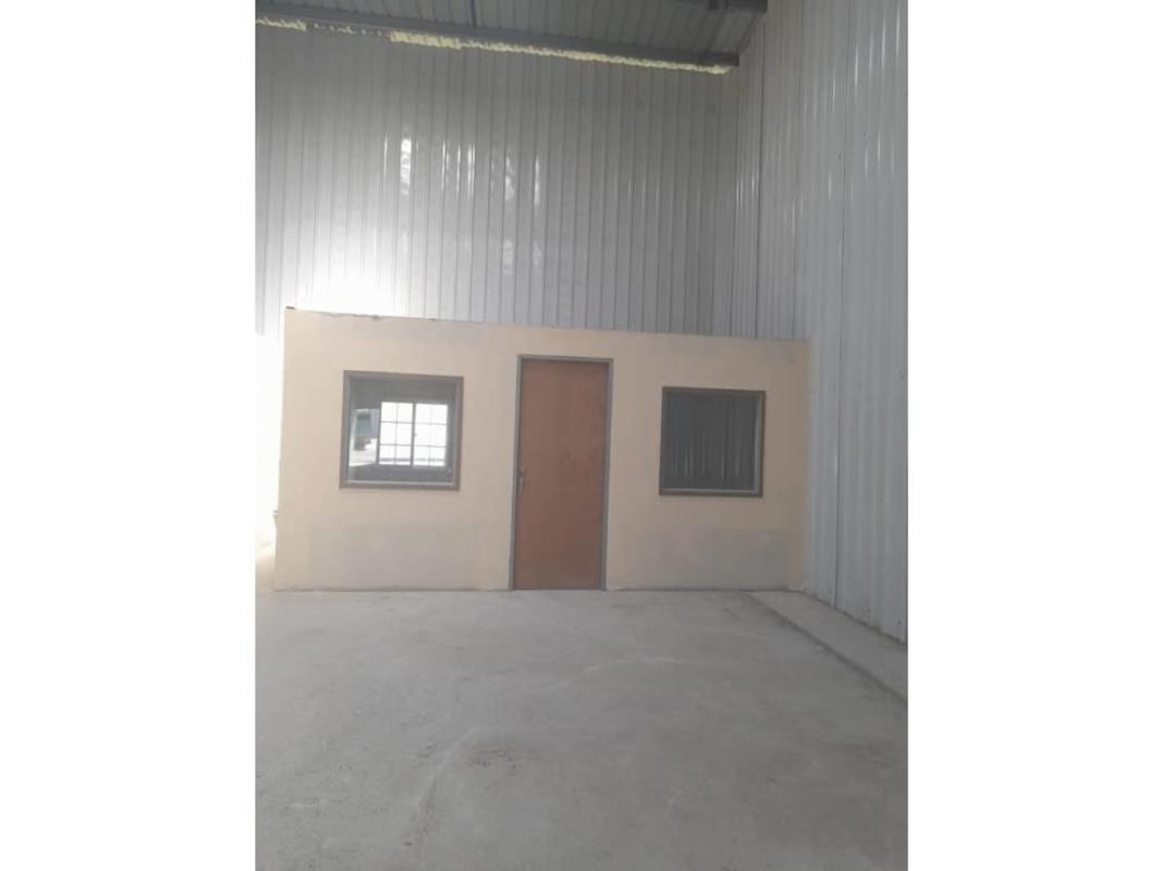 Spacious warehouse interior in Mañanitas Tocumen with high metal walls and integrated small beige office Panama City