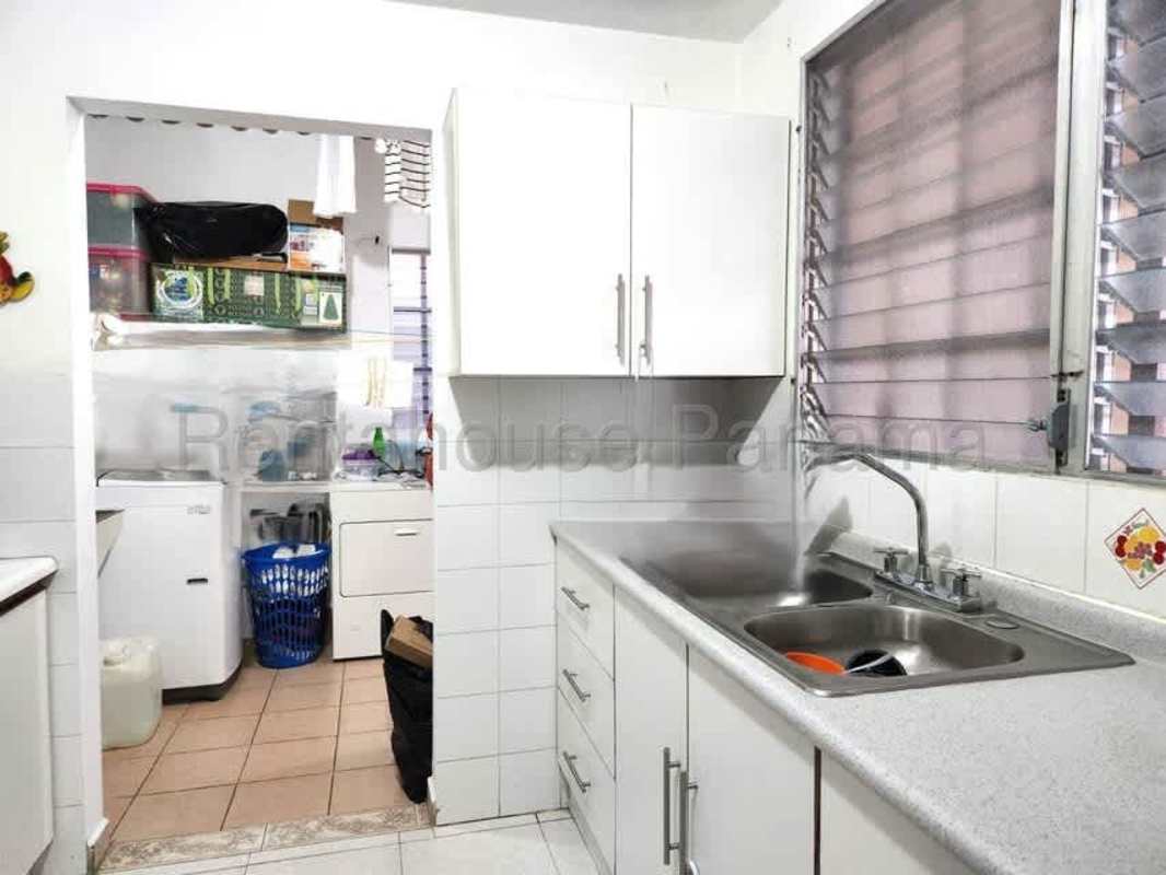 Traditional closed kitchen with laundry area in family house in Brisas del Golf Panama