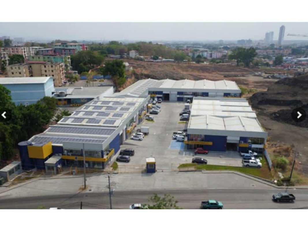Aerial view of industrial complex with multiple warehouse units, parking and urban surrounds in Panama City