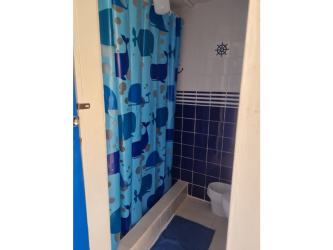 Simple bedroom with blue floral bedspread and wooden accents Punta Chame