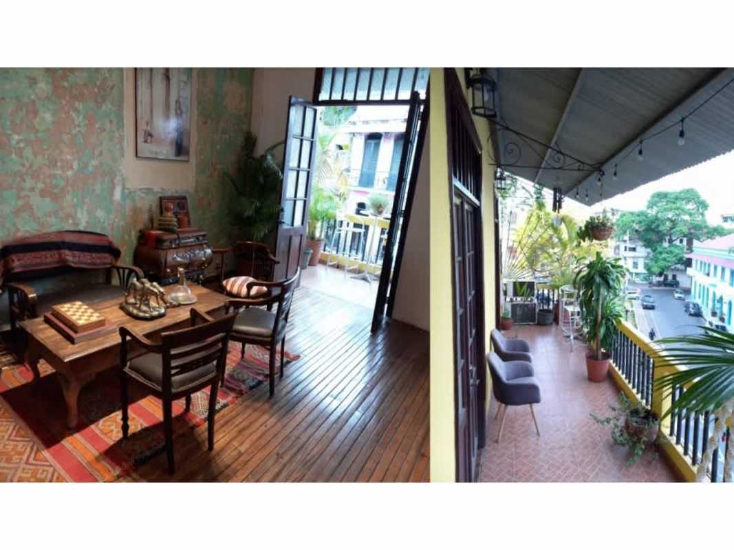 Colonial yellow facade of Casa Catalina with balconies lit up at night in Casco Viejo Panama