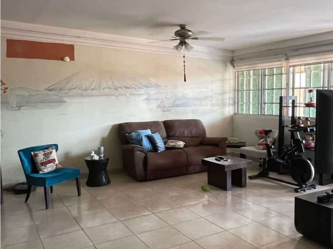 Enclosed laundry area with orange walls, tiled floors and corrugated roofing in backyard