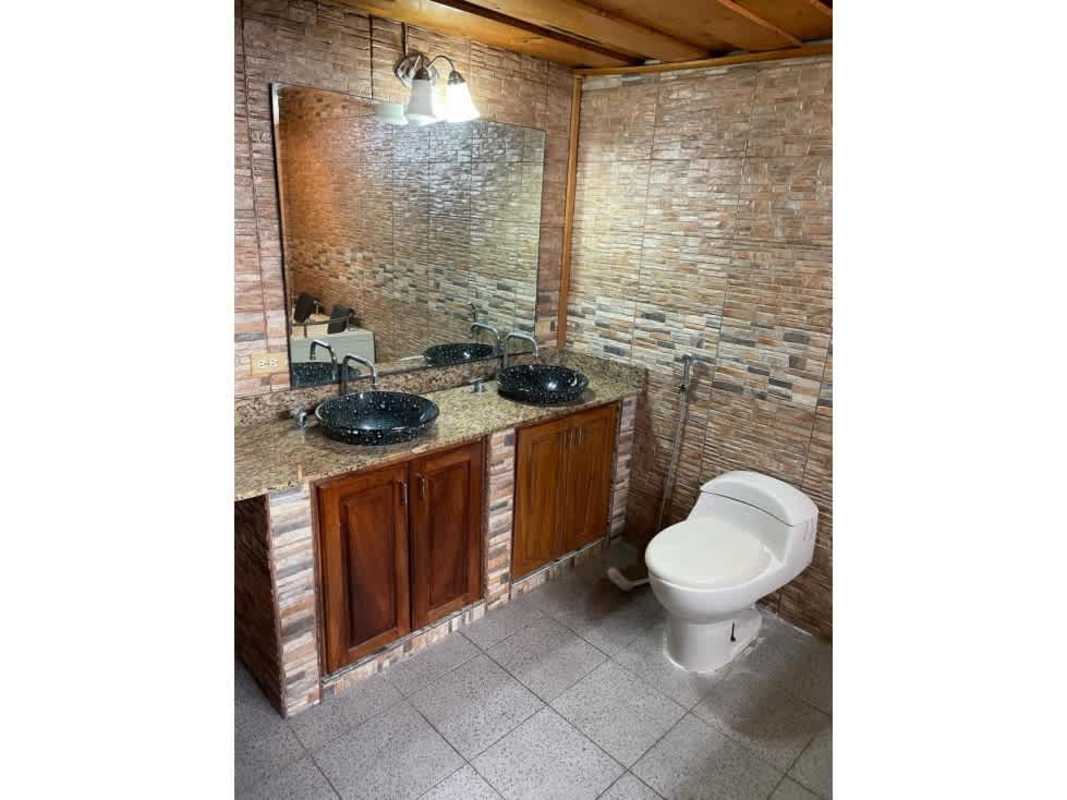 Rustic bathroom double vessel sink granite counter textured walls wooden cabinet Cerro Viento Panama